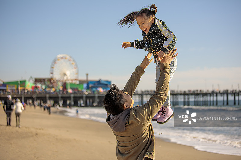 在圣莫尼卡冬季海滩野餐的多民族家庭图片素材