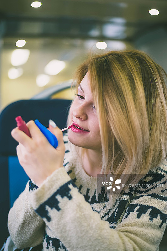 可爱的年轻女孩涂口红特写图片素材