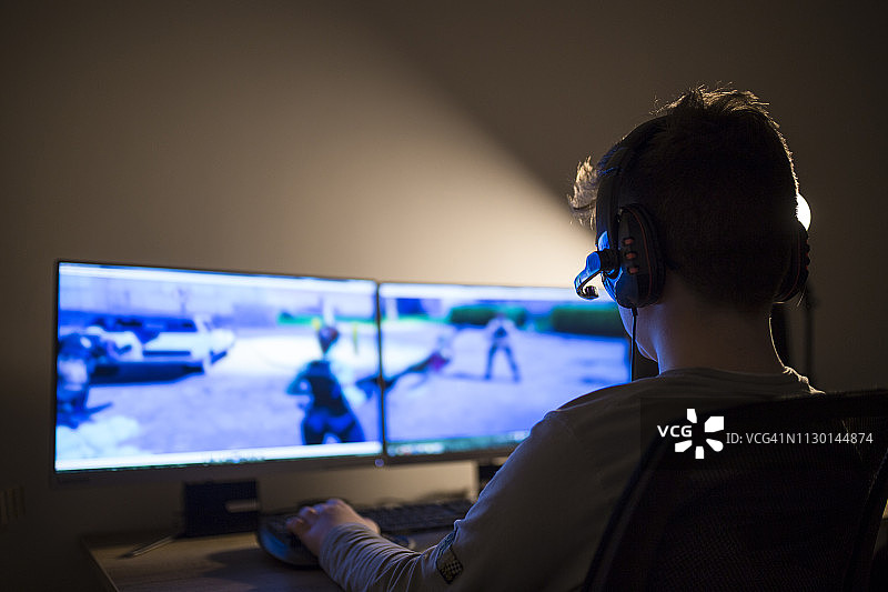 小男孩在家玩电脑游戏图片素材