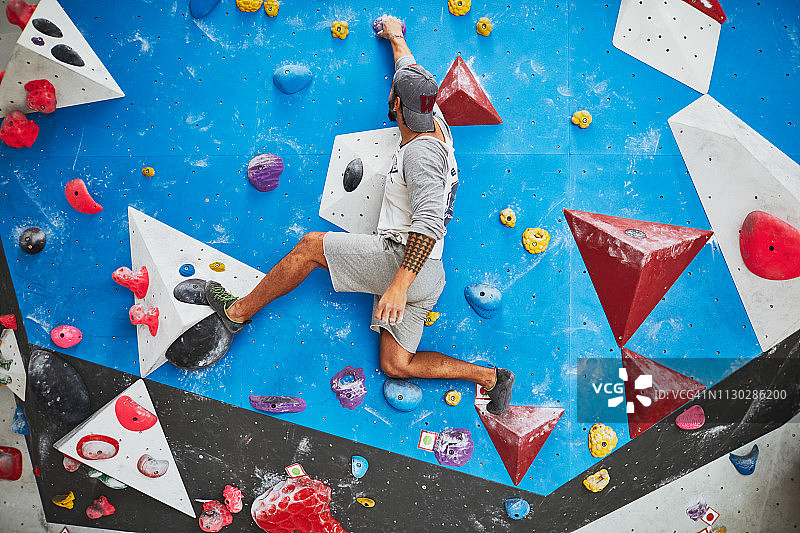 室内攀岩：男子攀登室内抱石墙图片素材