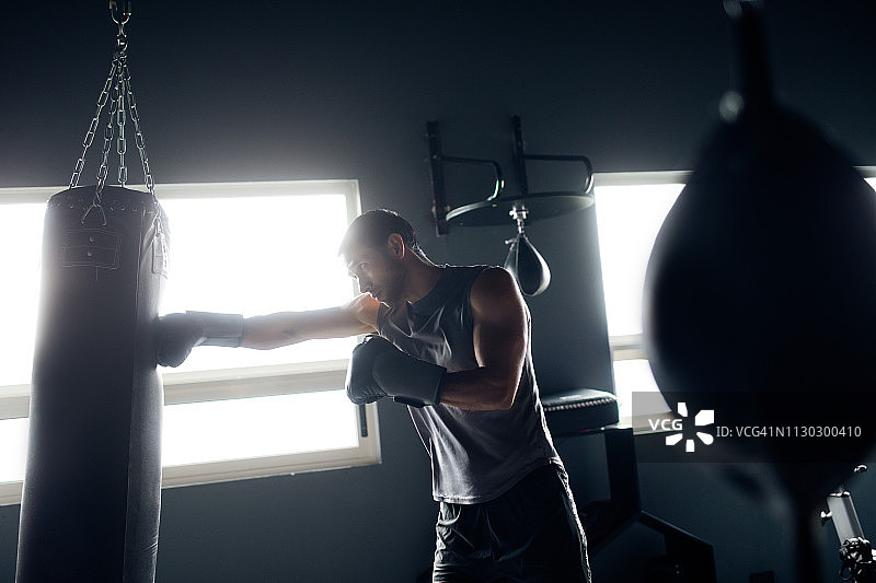 拉丁裔男人击打拳击沙袋图片素材