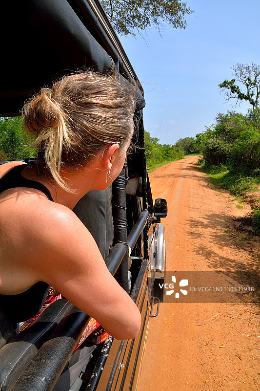 在国家公园里，女人从四轮驱动车里探出身子图片素材