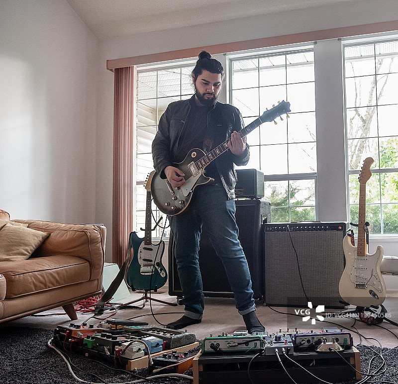音乐家在客厅用音效踏板演奏电吉他图片素材