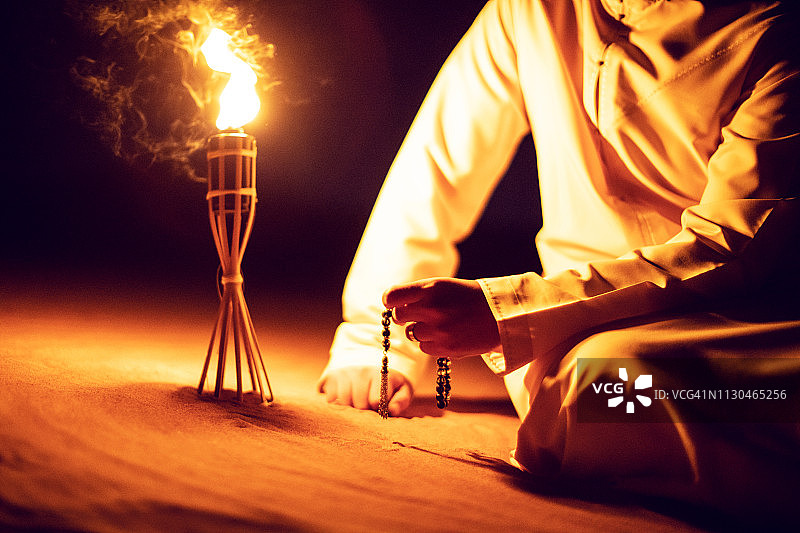 在沙漠中手持泰斯比赫的阿拉伯男人图片素材