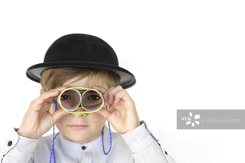 男孩用自制双筒望远镜观察图片素材