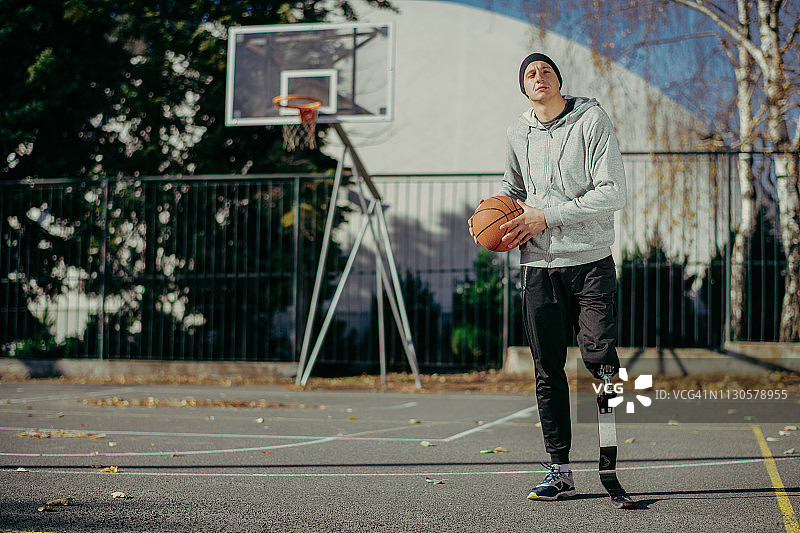 在篮球场上安装了假肢的年轻男人图片素材