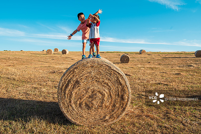 孩子们站在干草捆上玩耍图片素材