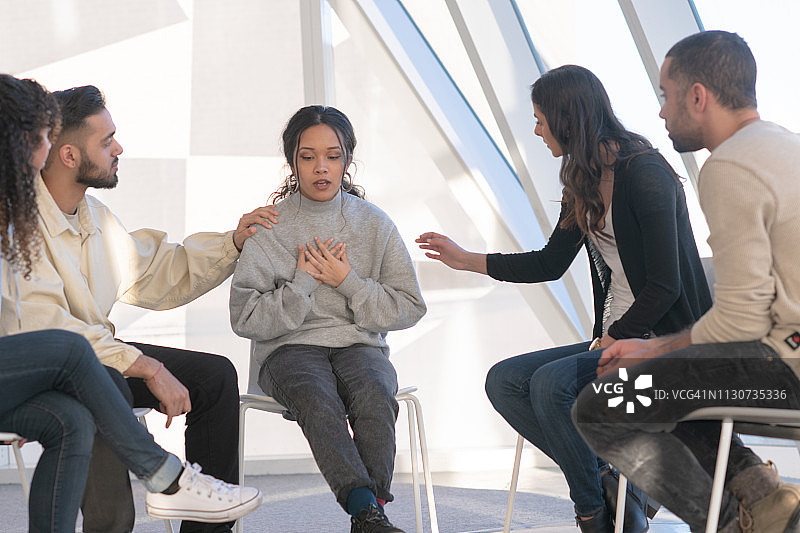 年轻人在团体治疗中安慰朋友图片素材