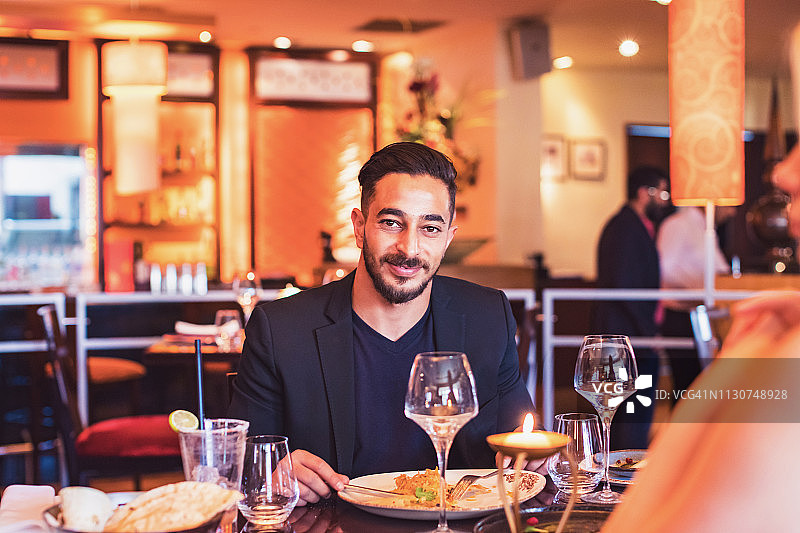 坐在高级餐厅的年轻中东男子肖像图片素材