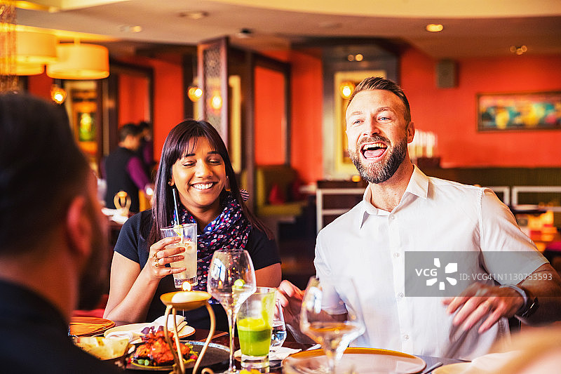 在餐厅里大声交谈的喧闹的朋友图片素材
