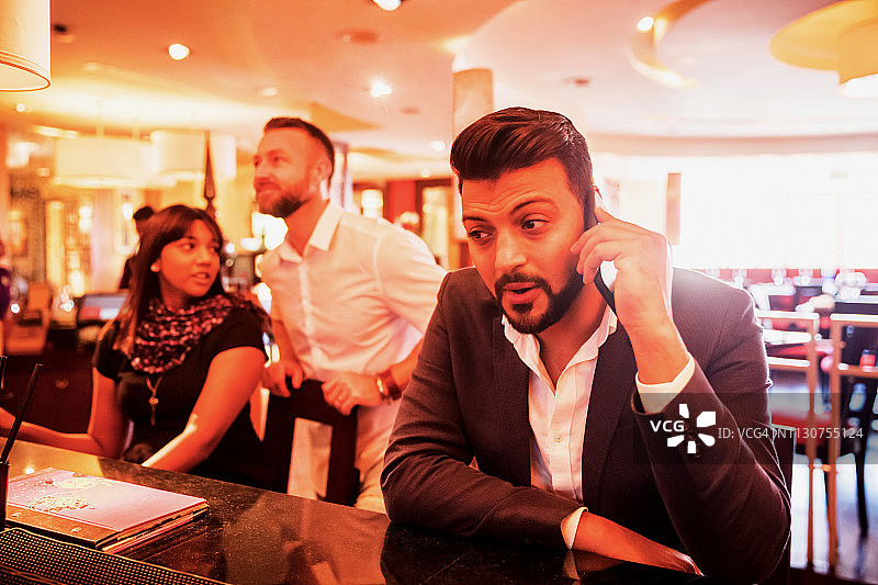 与朋友在一起时因电话而分心图片素材