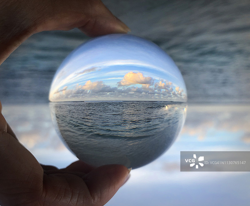 水晶球反射出蓝天、海洋、海浪和沙滩的美丽景色图片素材