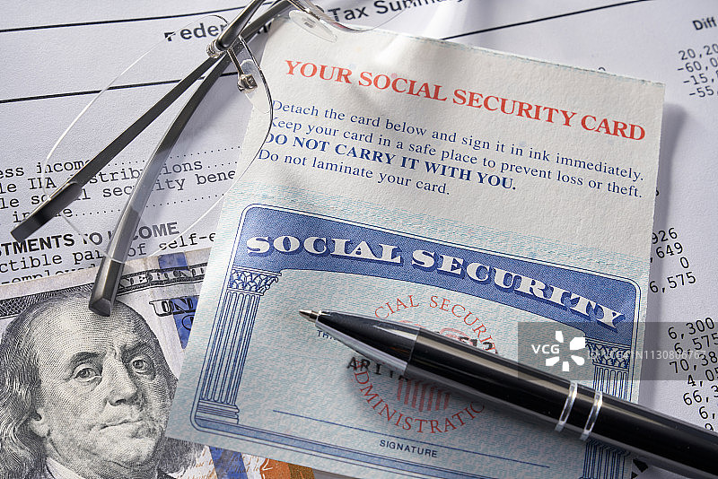 社会保障卡、笔和眼镜与100美元图片素材