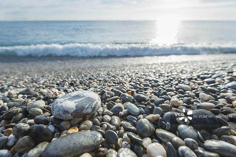 阳光照耀下的美丽海滩卵石景色图片素材