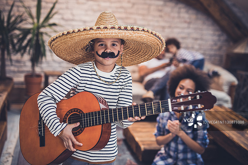 在家弹吉他的小墨西哥流浪乐队男孩图片素材