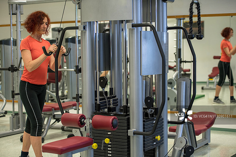 在欧洲健身房锻炼的年长红发女人图片素材