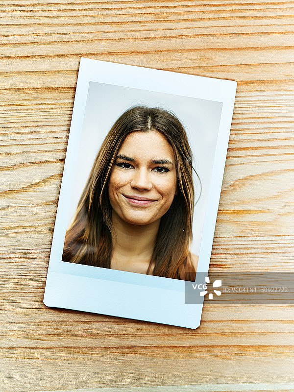 一位笑容满面的白人年轻女人的一次成像相机肖像图片素材