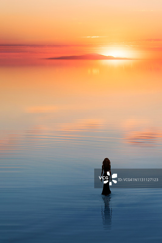 孤独的女人走向水面上的太阳图片素材
