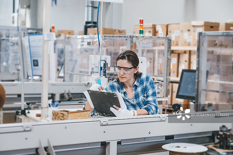 在工厂做笔记的女工人图片素材