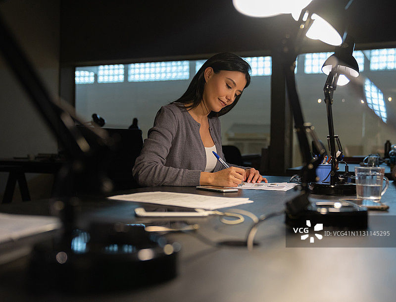 在办公室工作到很晚的女商人图片素材