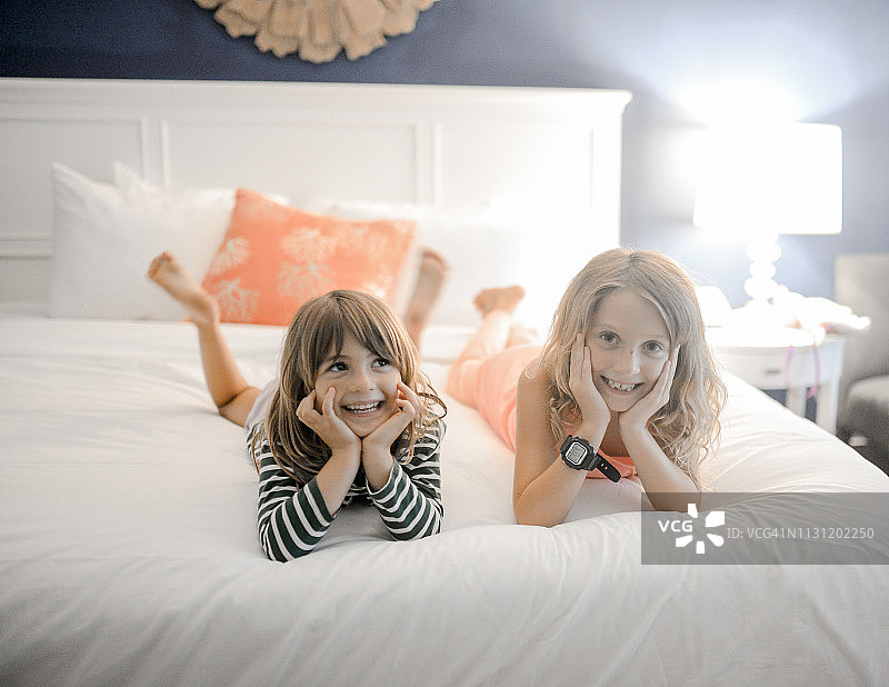 在酒店的床上玩耍的可爱儿童图片素材