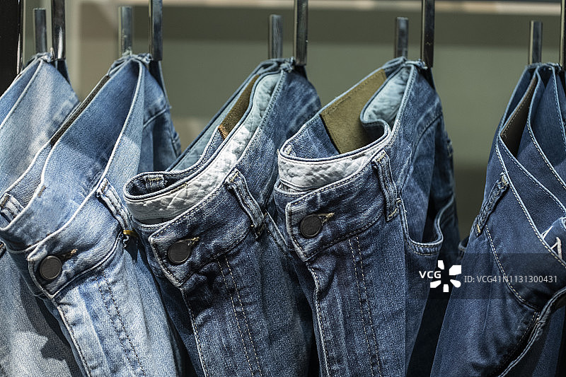 一排挂在布袋上的牛仔裤特写图片素材