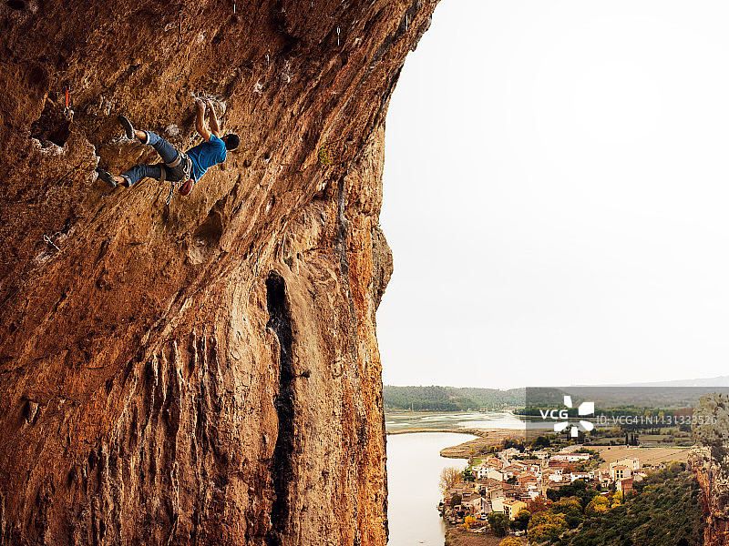 年轻人在仰 overhang 位置进行运动攀登图片素材