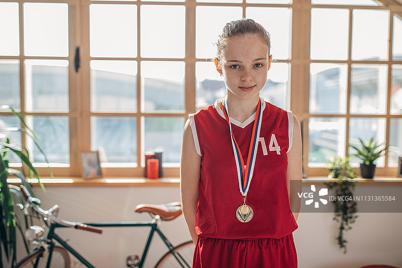 身穿篮球服、佩戴金牌的可爱女孩图片素材