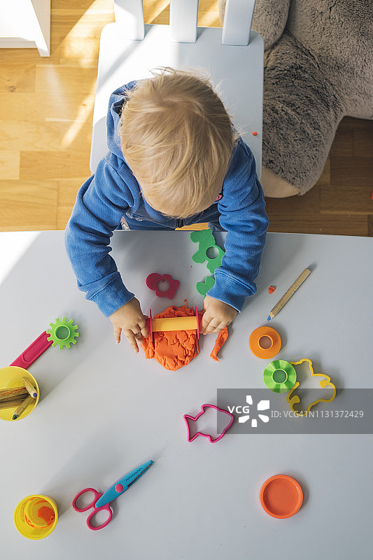 玩橡皮泥的女婴，俯视图片素材