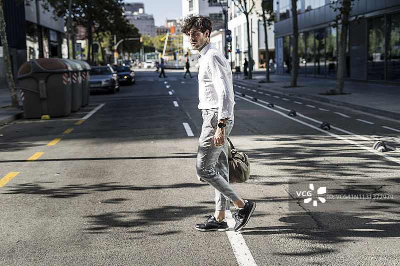 在城市里过马路的年轻男人图片素材