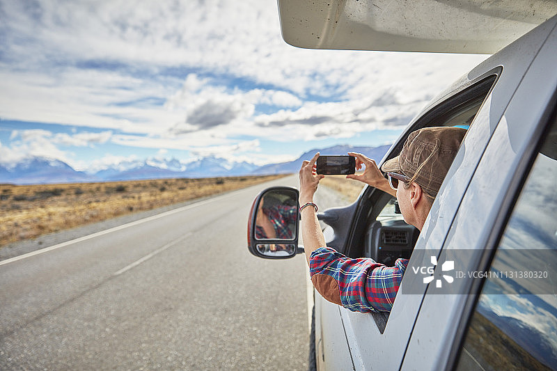 阿根廷巴塔哥尼亚菲茨罗伊峰：女子在房车上用手机拍照图片素材