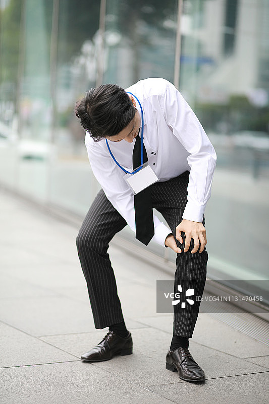 膝盖疼痛的商人图片素材