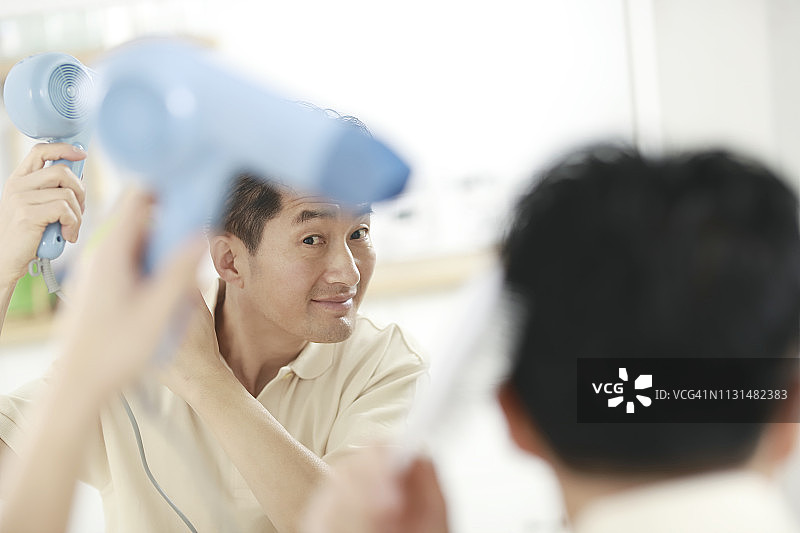 年长的男人吹干头发图片素材