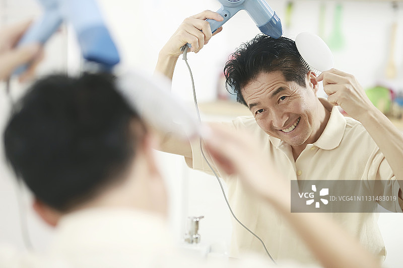 年长的男人吹干头发图片素材