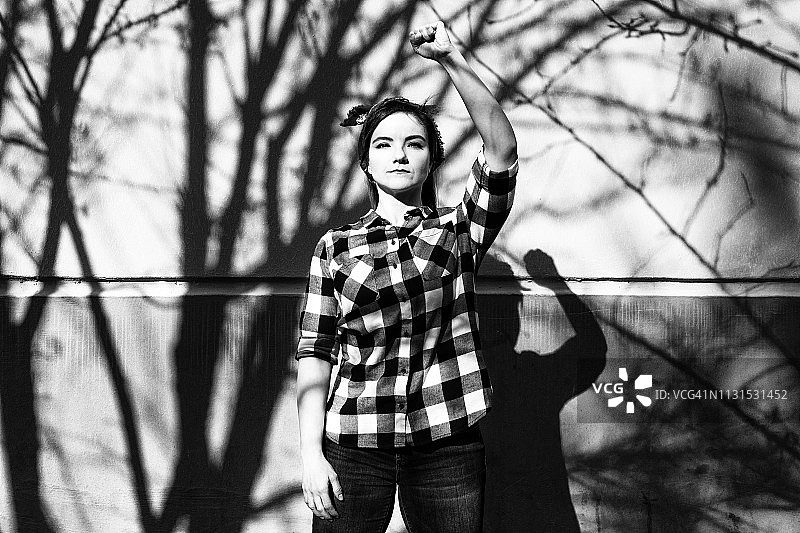 戴着头巾，举起拳头的年轻女活动家肖像图片素材