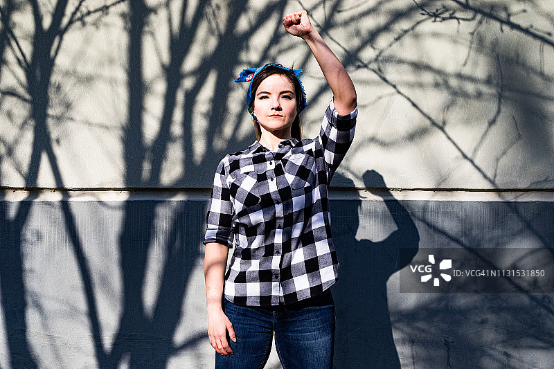 戴着头巾，举起拳头的年轻女活动家肖像图片素材