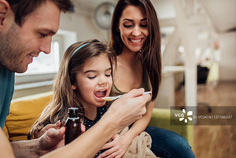 父母给女儿喂止咳糖浆图片素材