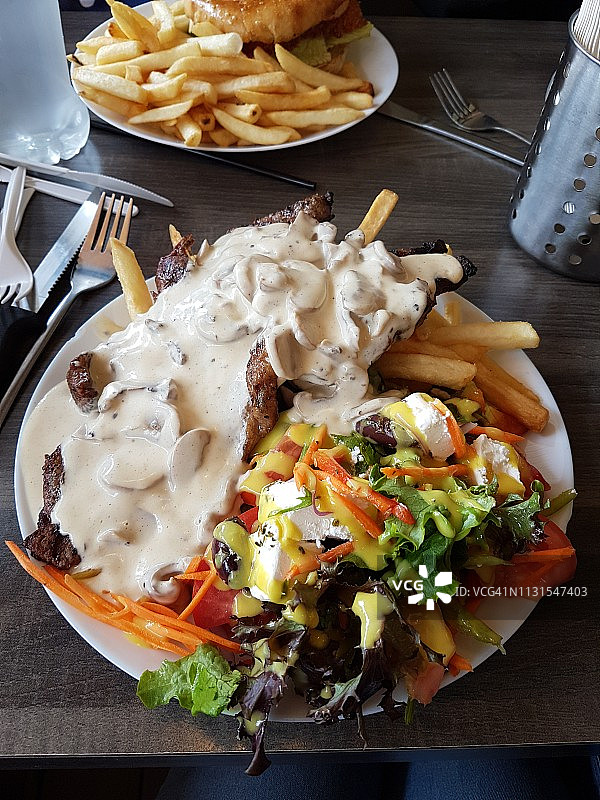 牛排配蘑菇酱、薯条和新鲜沙拉图片素材