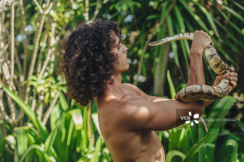 男人在野外手持大蛇图片素材