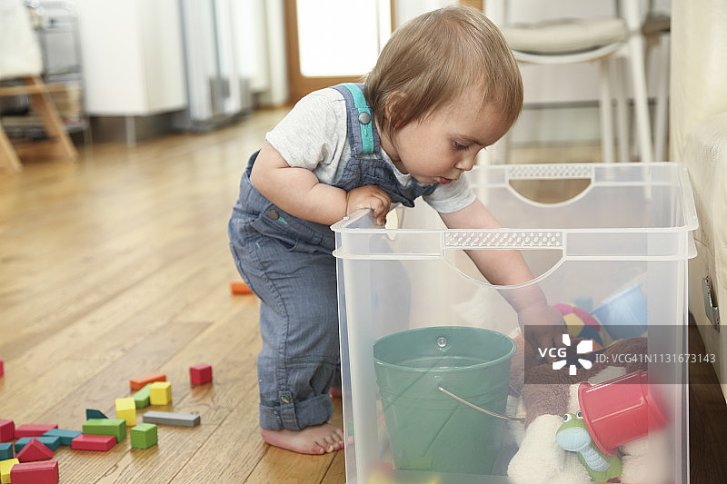 小男孩检查他的玩具箱图片素材