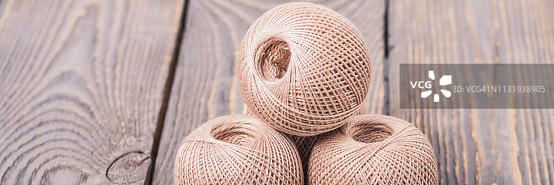 木质背景上的针织用毛线球图片素材