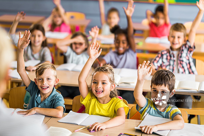 课堂上知道答案的快乐小学生们图片素材