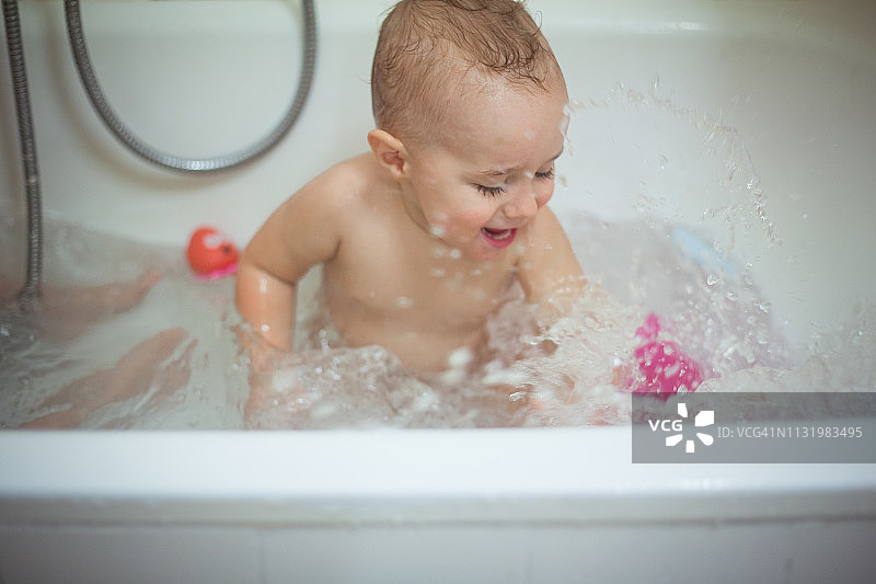 在浴缸里玩水的男婴图片素材