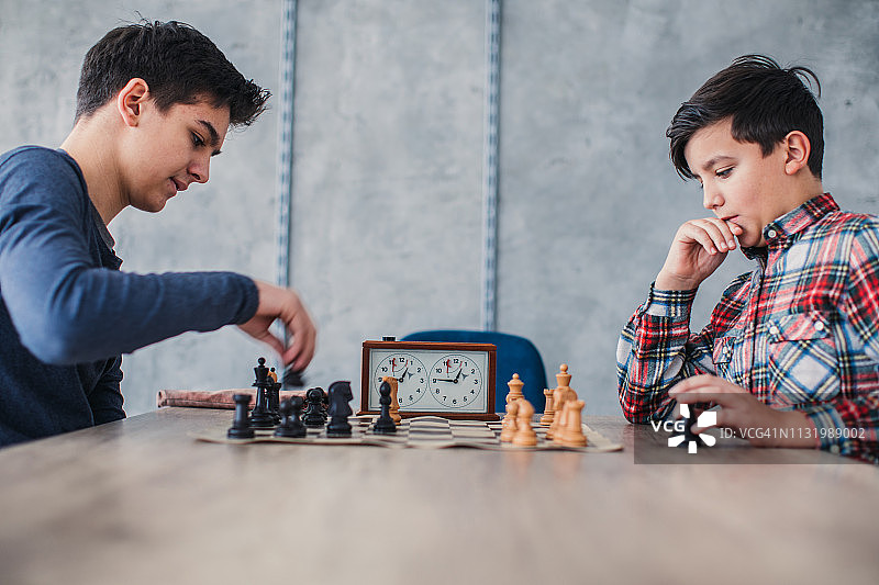 两个聪明的男孩在国际象棋学校里下棋图片素材