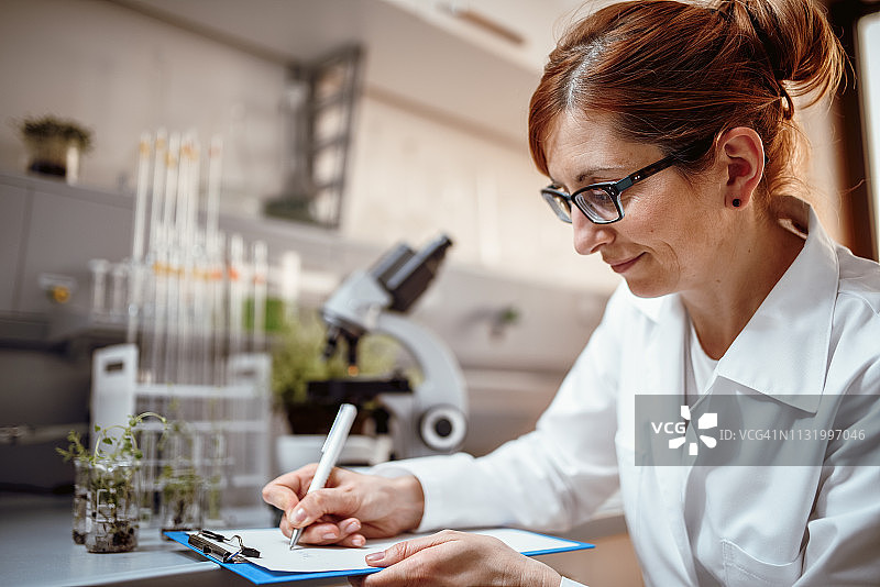 女科学家正在做研究笔记图片素材
