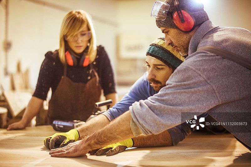 木匠学徒向同事学习制作桌面图片素材