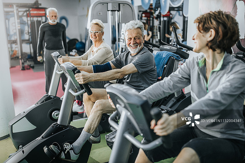 快乐的活跃老年人在健身房里一边交谈一边上锻炼课图片素材