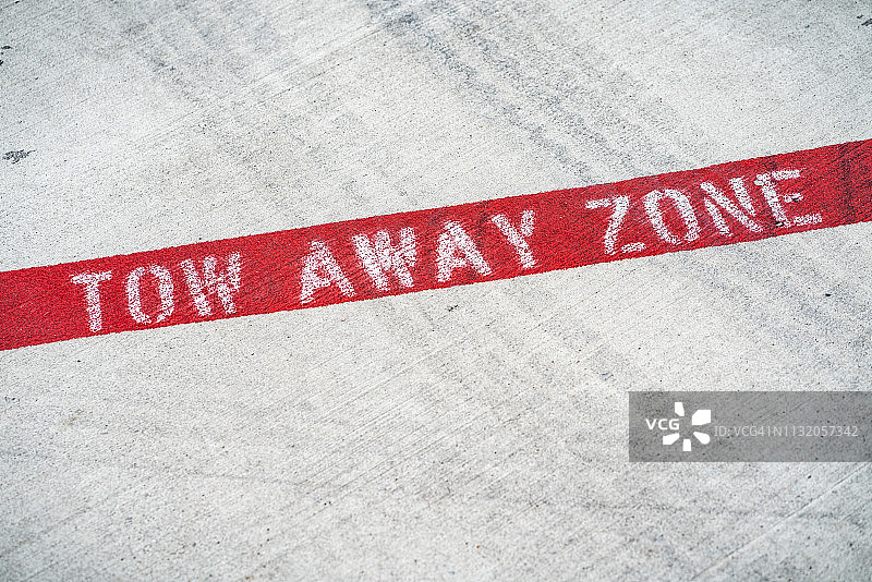 混凝土路面上的拖吊区禁止停车标志图片素材