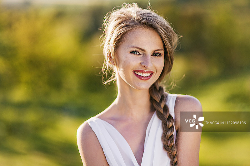 身处绿色自然风光中的年轻金发女子图片素材