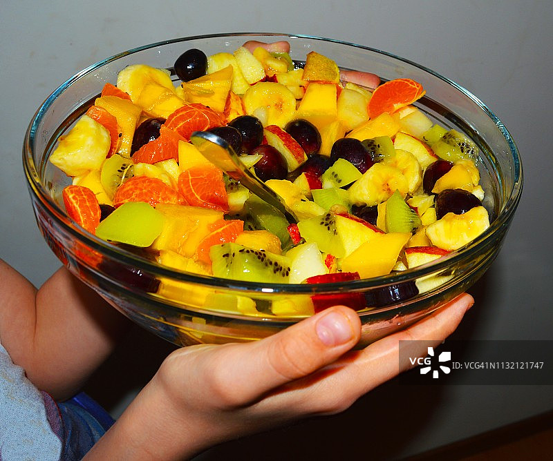 手捧玻璃碗装自制水果沙拉图片素材